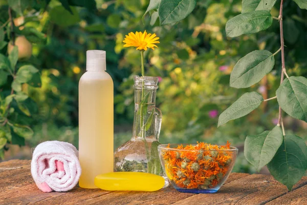 Toalha, sabão com extrato de calêndula, flores de calêndula em um frasco com fundo natural . — Fotografia de Stock