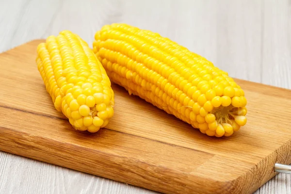 Обробна дошка з вареною кукурудзою на столі . — стокове фото