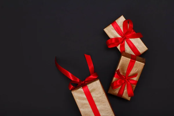 Geschenkdozen met rode linten op zwarte achtergrond. — Stockfoto