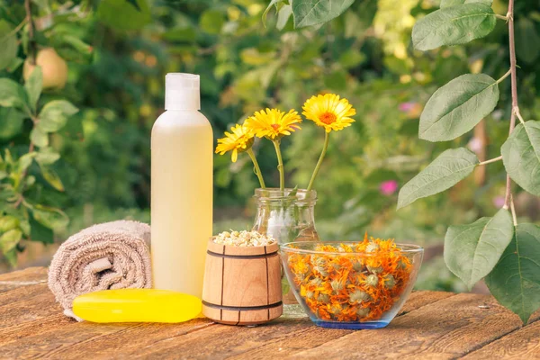 Toalha, sabão com extrato de calêndula, flores de calêndula em um frasco com fundo natural . — Fotografia de Stock