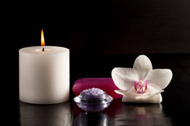 Spa için mum, deniz tuzu, sabun ve beyaz orkide çiçek.