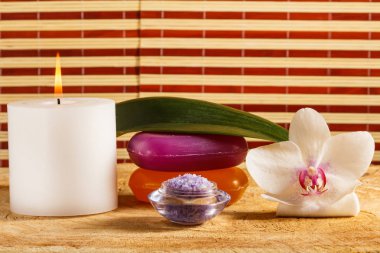 Spa için mum, deniz tuzu, sabun ve beyaz orkide çiçek.