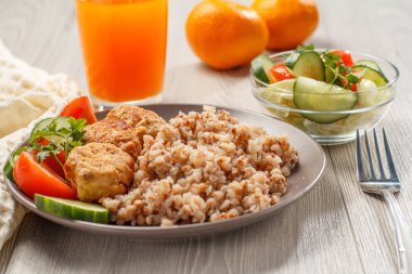 Karabuğday, kızarmış et pirzola ve taze salatalık ve domates parçaları ile Plaka