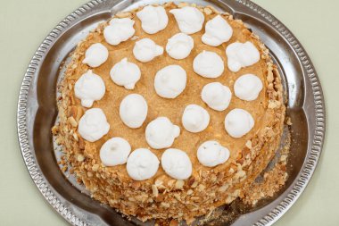 Bisküvi kek metal tepsiüzerinde krem şanti ile süslenmiş.