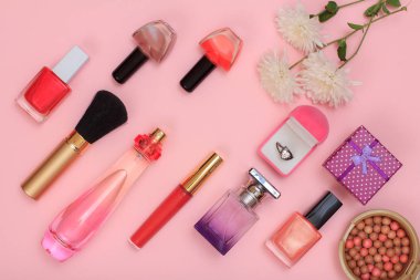 Hediye kutuları, kadın kozmetik ve pembe bir arka plan üzerinde çiçekler.