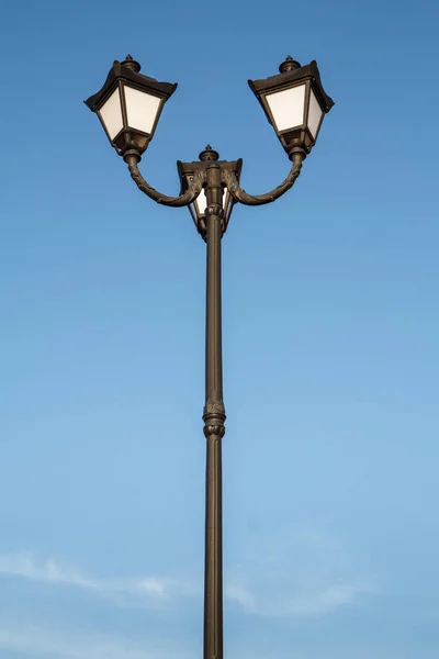 Vintage black street lamppost with three lamps.