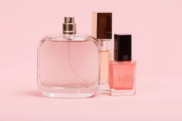 Perfumy i kosmetyki damskie na różowym tle. — Zdjęcie stockowe
