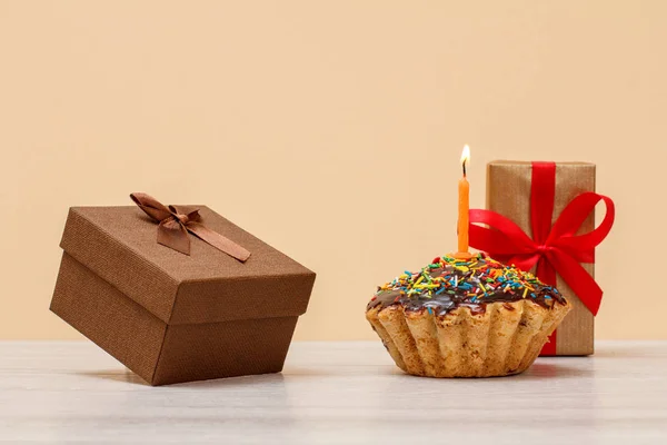 Yanan şenlikli mum ve hediye kutuları ile lezzetli doğum günü muffin. — Stok fotoğraf