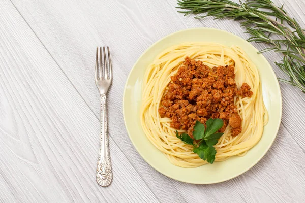 Espaguetis boloñeses en un plato con tenedor de metal . —  Fotos de Stock