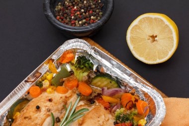 Kesme tahtası üzerinde sebze ile metal kapta Pişmiş tavuk göğüsleri veya fileto.