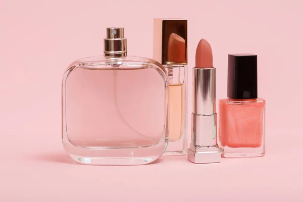 Women perfumes and cosmetics on a pink background. — Stock Photo, Image