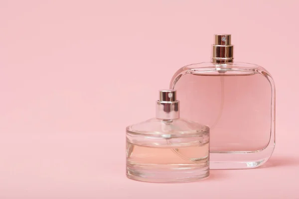 Bouteilles avec des femmes parfum sur le fond rose . — Photo