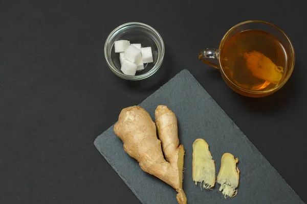Health remedy foods for cold and flu relief with ginger and tea on a black background. Top view. Foods That Boost the Immune System.