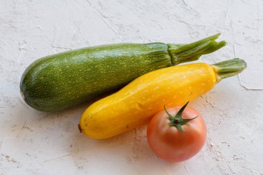 Beyaz yapılı arka planda sadece domates ve kabak topladım. Sadece sebze topladım. Üst görünüm.