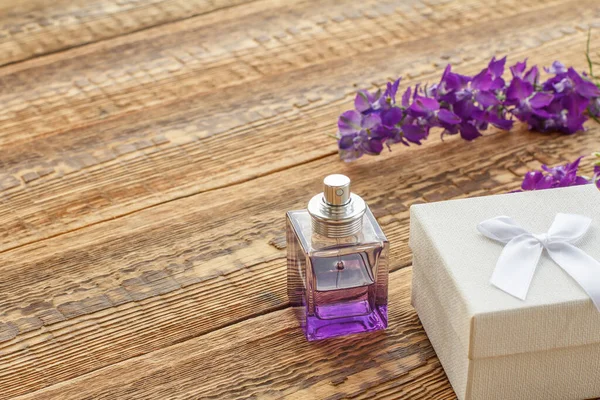 Cadeaudoosje Flesje Parfum Houten Planken Versierd Met Lila Bloemen Bovenaanzicht — Stockfoto