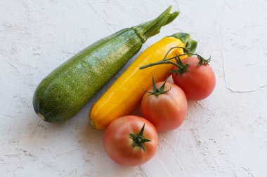 Sadece beyaz yapılı arka planda domates ve kabak topladım. Sadece sebze topladım. Üst görünüm.