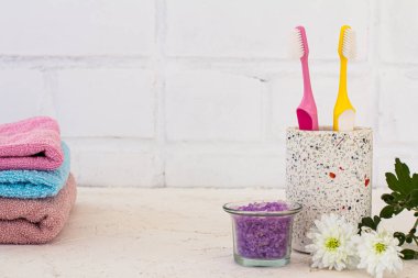 Beyaz arka planda diş fırçası, havlu ve deniz tuzu olan bir kutu. Aksesuarları yıka.