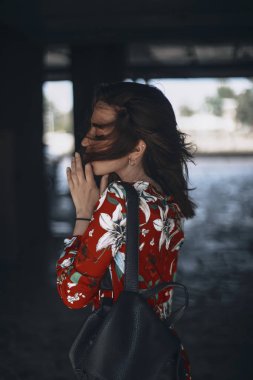 kırmızı tulum etmek tropikal süsler kadında kendini asıyor. esmer ile saç kesimi arayın. 