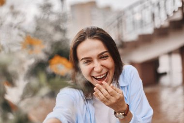 güzel bir kadın bir buket çiçek verilir. mavi bir gömlek ve T-shirt ile alan buket alır bir beyaz giymiş bir esmer. Bayan mutlu ve ile yüz.