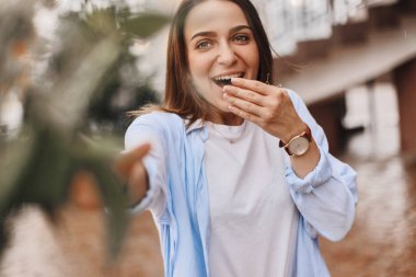 güzel bir kadın bir buket çiçek verilir. mavi bir gömlek ve T-shirt ile alan buket alır bir beyaz giymiş bir esmer. Bayan mutlu ve ile yüz.