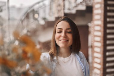 güzel bir kadın bir buket çiçek verilir. mavi bir gömlek ve T-shirt ile alan buket alır bir beyaz giymiş bir esmer. Bayan mutlu ve ile yüz.