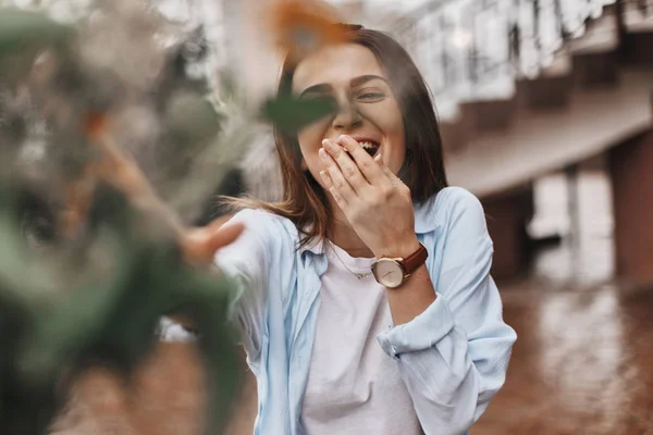 güzel bir kadın bir buket çiçek verilir. mavi bir gömlek ve T-shirt ile alan buket alır bir beyaz giymiş bir esmer. Bayan mutlu ve ile yüz.