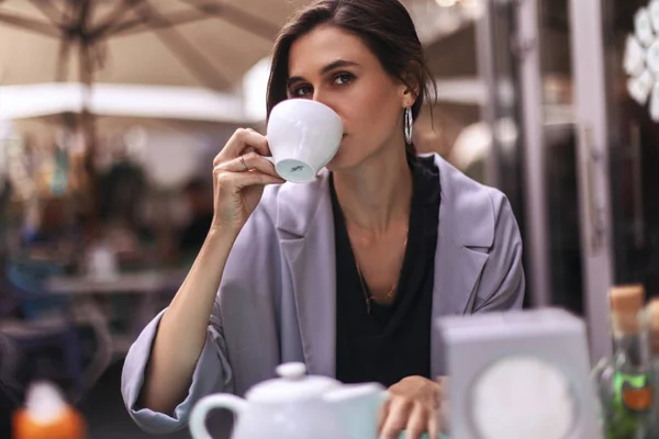 Attractive brunette bussines woman with tail drinking coffee or tea in restaurant. cofee break — Stock Photo, Image