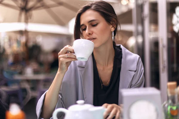 Attractive brunette bussines woman with tail drinking coffee or tea in restaurant. cofee break — Stock Photo, Image