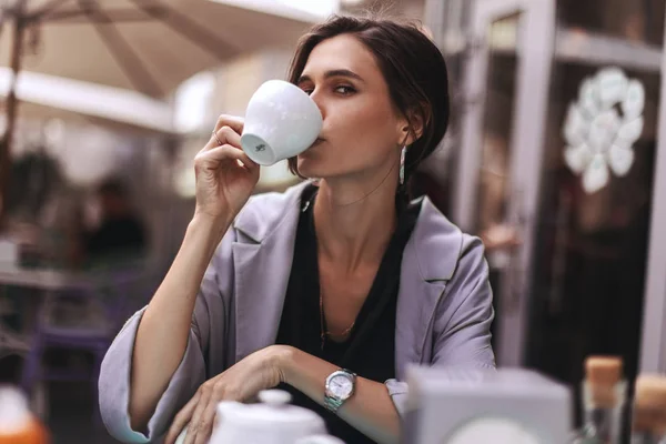 Attractive brunette bussines woman with tail drinking coffee or tea in restaurant. cofee break — Stock Photo, Image
