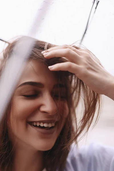 Mujer atractiva debajo del paraguas con camisa azul. La chica parece feliz. Lluvia — Foto de Stock