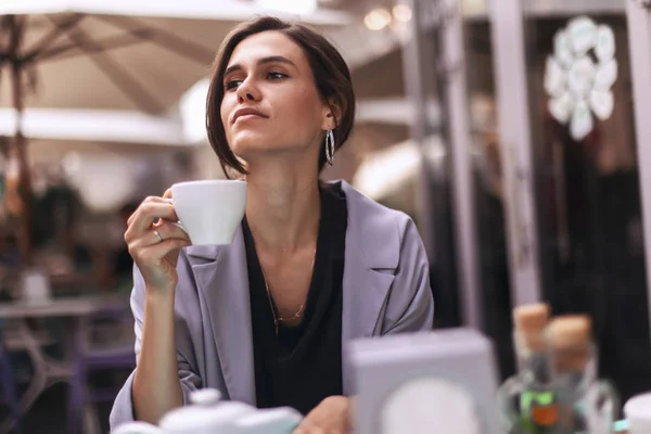 Attractive brunette bussines woman with tail drinking coffee or tea in restaurant. cofee break — Stock Photo, Image