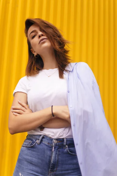 Retrato mulher atraente no fundo amarelo. Ela olha para a câmera pretensiosa ou arrogante. Menina morena com cabelo curto . — Fotografia de Stock