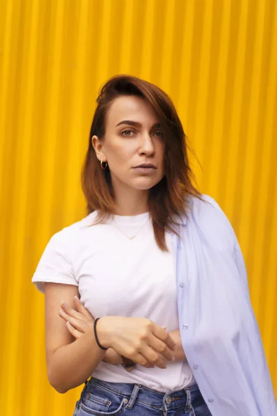 Retrato mulher atraente no fundo amarelo. Ela olha para a câmera pretensiosa ou arrogante. Menina morena com cabelo curto . — Fotografia de Stock