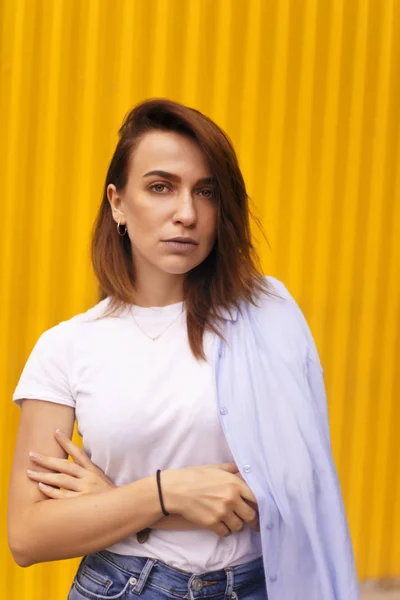 Retrato mulher atraente no fundo amarelo. Ela olha para a câmera pretensiosa ou arrogante. Menina morena com cabelo curto . — Fotografia de Stock