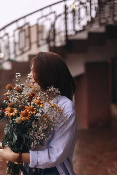 Portret van mooie vrouw die genieten van bloemen. Boeket van de bloemen van de velden — Stockfoto