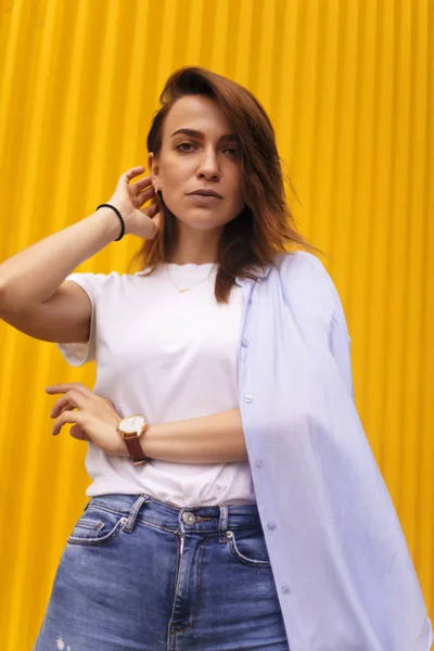 Retrato mujer atractiva sobre fondo amarillo. mira en cámara pretenciosa o arrogante. Chica morena con el pelo corto . —  Fotos de Stock