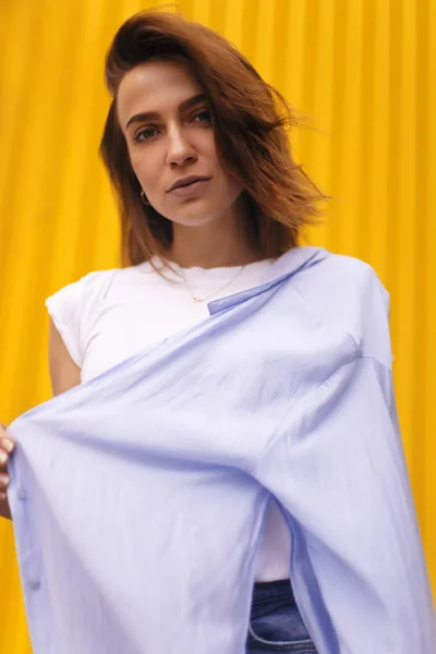 Retrato mujer atractiva sobre fondo amarillo. mira en cámara pretenciosa o arrogante. Chica morena con el pelo corto . —  Fotos de Stock