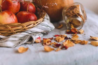 Tarçın ile natürmort sicim, kabak, elma bir hasır sepet stand bankada bir çizgili keten kumaş, ceviz ve çiçek yaprakları üzerine sarılmış. Sonbahar ya da kış ev rahatlığında kavramı.