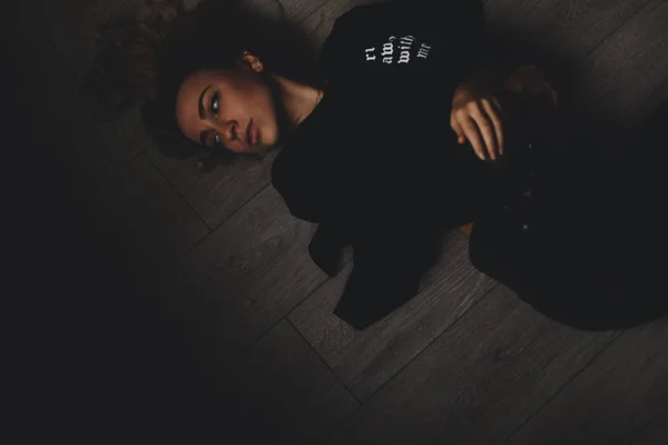 有吸引力的性感的女人躺在地板上。她看起来很性感。辣妹穿完全黑色的样子. — 图库照片