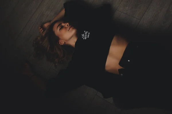 Vonzó szexi nő fekszik a földön. Úgy néz ki, érzékiség. Forró lány visel teljes fekete megjelenés. — Stock Fotó