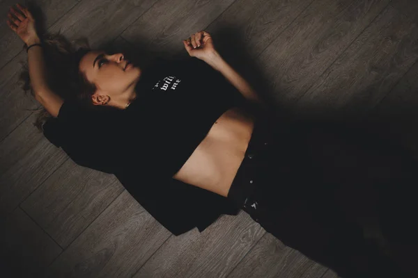 Привлекательная сексуальная женщина лежит на полу. Она выглядит чувственной. Горячая девушка носит полностью черный взгляд . — стоковое фото