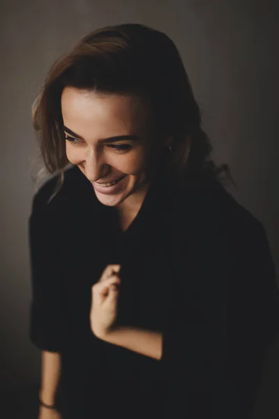 Retrato de mulher atraente feliz vestindo camisa preta. Morena encaracolado mulher cabelo. Mulher olha para o lado . — Fotografia de Stock