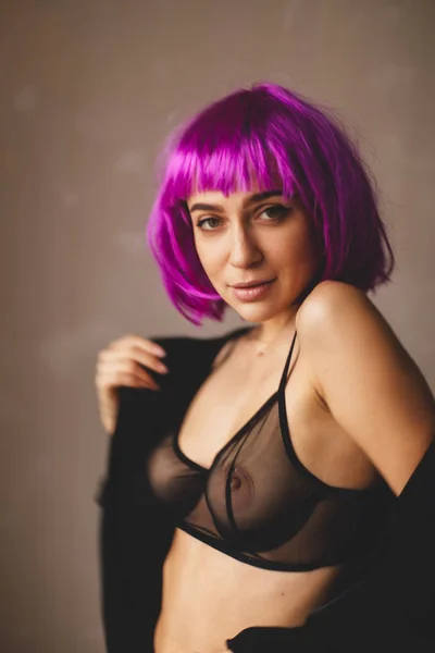 Aantrekkelijk meisje draagt roze pruik en zwart lingerie, shirt. Vrouwen zijn close-up van een zwart shirt. Sexy meisje opstijgen zetten of op zwarte shirt. — Stockfoto