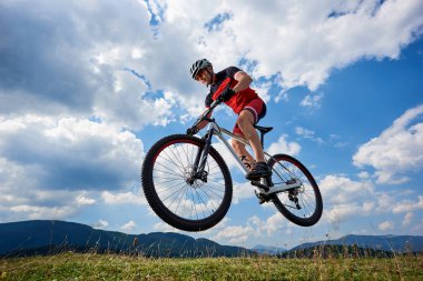 Profesyonel spor giyim ve kask arka plan açık aşırı spor kavramı üzerinde gökyüzü ve uzak dağ bisiklet atlama spor sporcu bisikletçi 