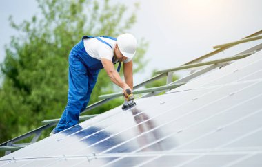 İnşaat işçisi Fotoğraf volta panel güneş sistemi için tornavida kullanarak bağlanır. Profesyonel yükleme ve güneş sistemi, alternatif enerji ve finansal yatırım konsept İnşaat.