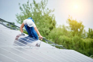 İnşaat işçisi Fotoğraf volta panel güneş sistemi için tornavida kullanarak bağlanır. Profesyonel yükleme ve güneş sistemi, alternatif enerji ve finansal yatırım konsept İnşaat.