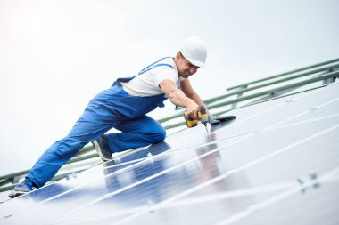 İnşaat işçisi Fotoğraf volta panel güneş sistemi için tornavida kullanarak bağlanır. Profesyonel yükleme ve güneş sistemi, alternatif enerji ve finansal yatırım konsept İnşaat.