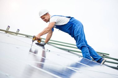 İnşaat işçisi Fotoğraf volta panel güneş sistemi için tornavida kullanarak bağlanır. Profesyonel yükleme ve güneş sistemi, alternatif enerji ve finansal yatırım konsept İnşaat.
