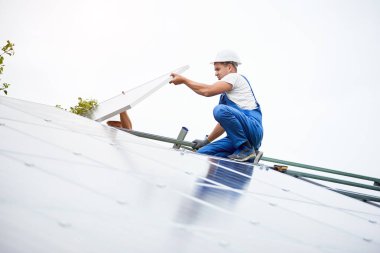 İnşaat işçisi Fotoğraf volta panel güneş sistemi için tornavida kullanarak bağlanır. Profesyonel yükleme ve güneş sistemi, alternatif enerji ve finansal yatırım konsept İnşaat.