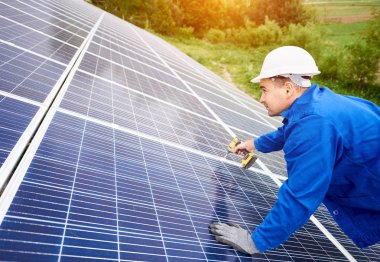 İnşaat işçisi Fotoğraf volta panel güneş sistemi için tornavida kullanarak bağlanır. Profesyonel yükleme ve güneş sistemi, alternatif enerji ve finansal yatırım konsept İnşaat.